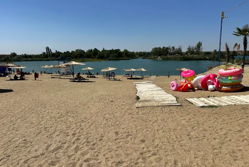 Plajă cu nisip și umbreluțe la Lacul Ghioroc